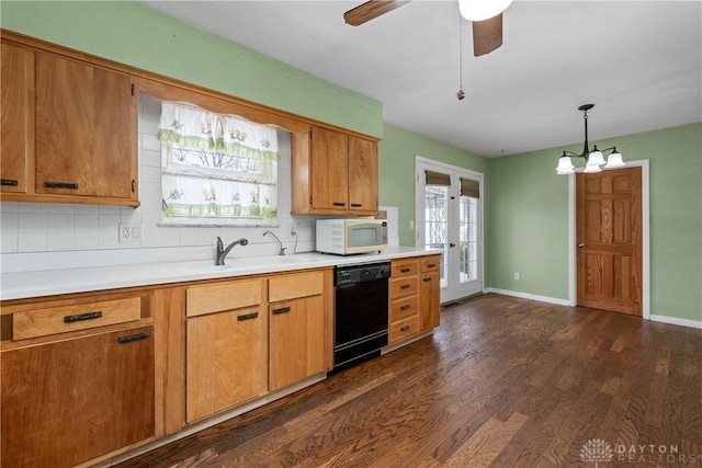 kitchen featuring decorative backsplash, sink, black dishwasher, and hanging light fixtures