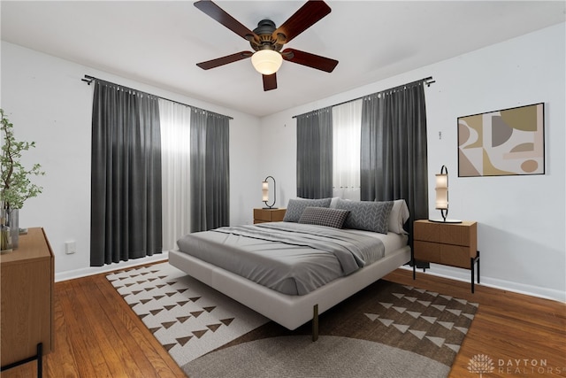 bedroom with ceiling fan and dark hardwood / wood-style flooring