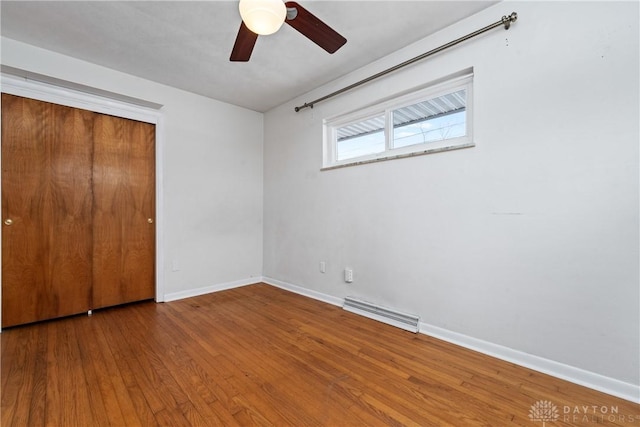 unfurnished bedroom featuring hardwood / wood-style floors, a closet, and ceiling fan