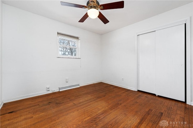 unfurnished bedroom with ceiling fan, a closet, and dark wood-type flooring