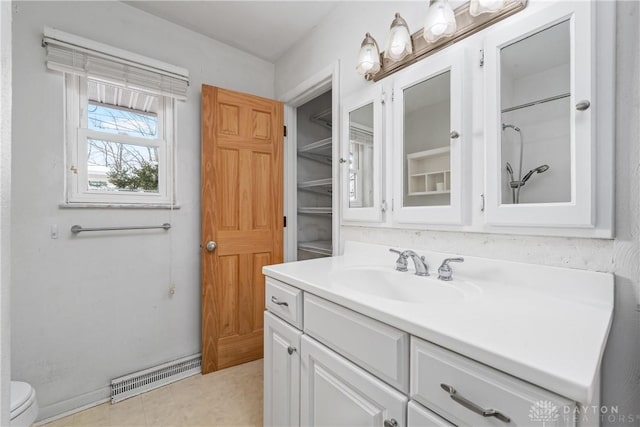 bathroom with vanity, toilet, and a shower