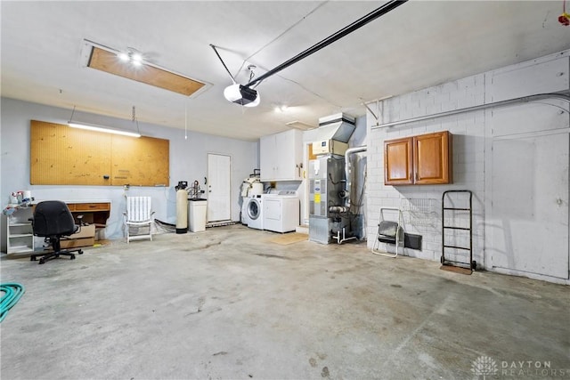 garage featuring washer and dryer, a garage door opener, and heating unit