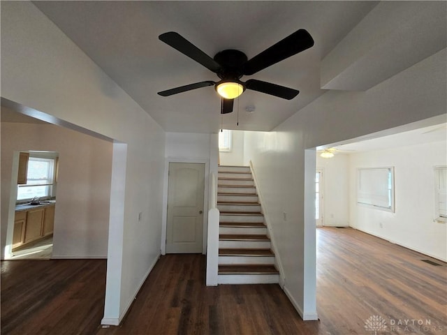 stairway with ceiling fan, wood-type flooring, and sink