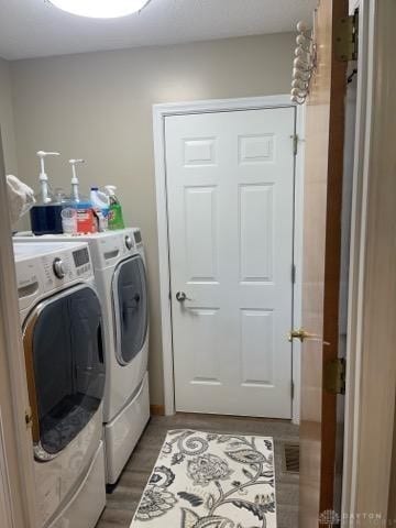 laundry area with dark hardwood / wood-style flooring and washer and clothes dryer