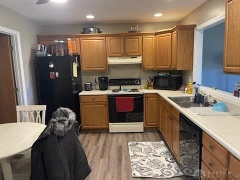 kitchen featuring sink, hardwood / wood-style flooring, and black appliances