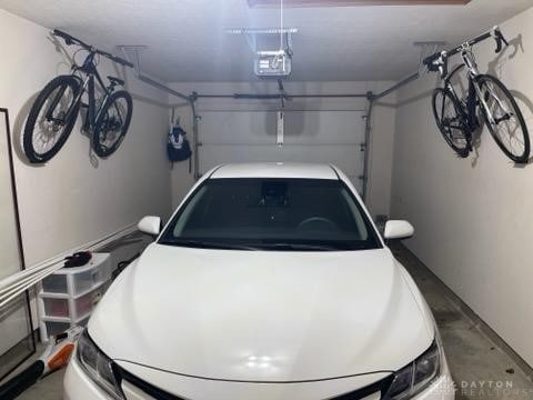 garage with a carport and a garage door opener