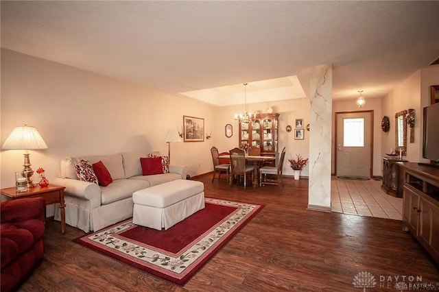 living room featuring dark hardwood / wood-style flooring and an inviting chandelier