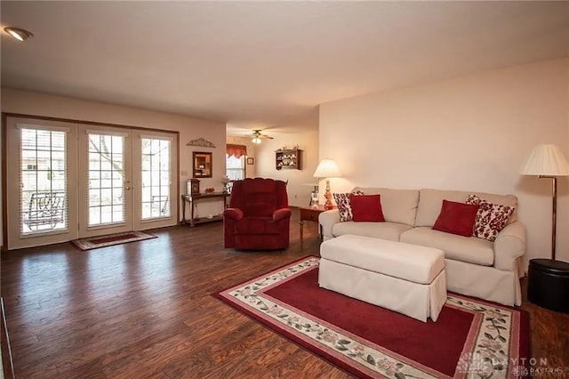 living room with ceiling fan and dark wood-type flooring