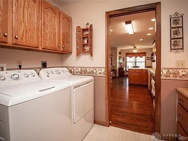 laundry room featuring cabinets, ceiling fan, and washing machine and clothes dryer