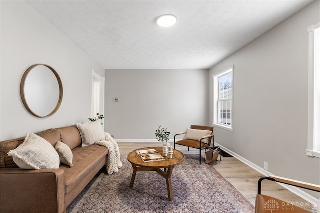 living room featuring a textured ceiling and light wood-type flooring