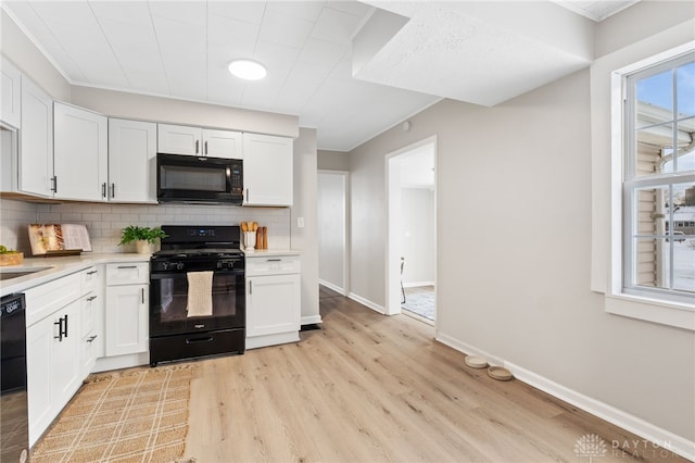 kitchen featuring white cabinets, backsplash, and black appliances