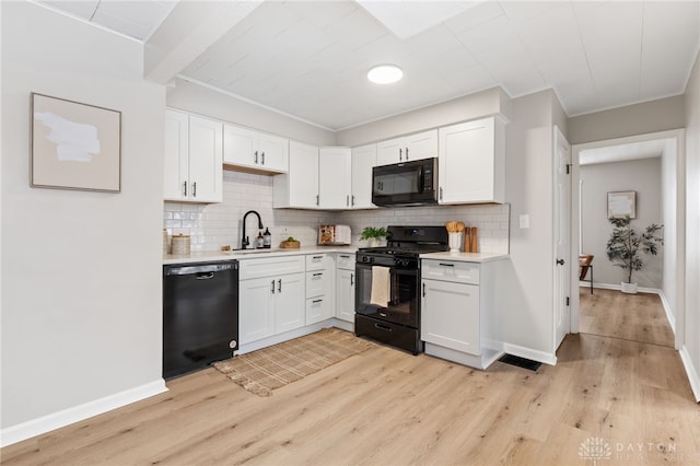 kitchen featuring white cabinets, light wood-type flooring, and black appliances