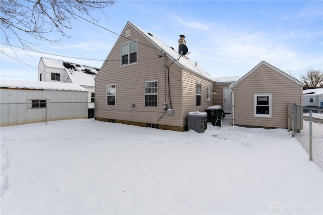 snow covered back of property with central AC unit