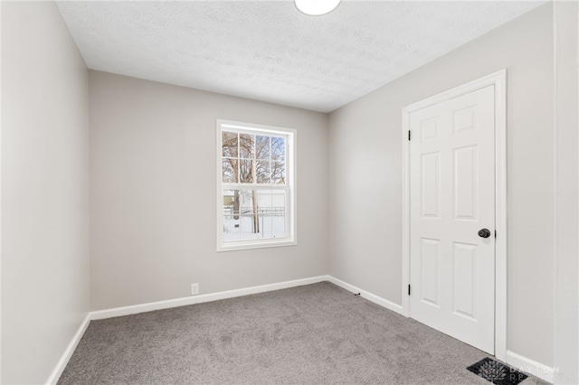 unfurnished room with a textured ceiling and carpet