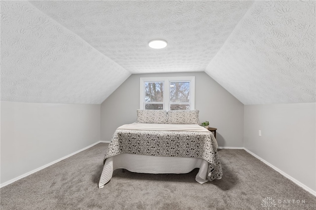 carpeted bedroom featuring lofted ceiling and a textured ceiling