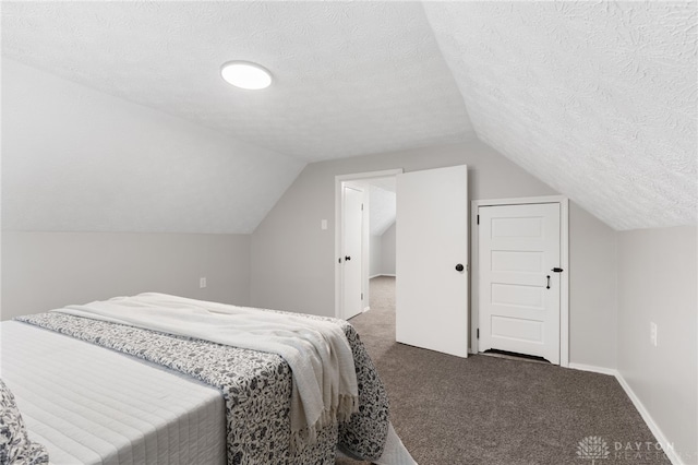 bedroom with dark carpet, vaulted ceiling, and a textured ceiling