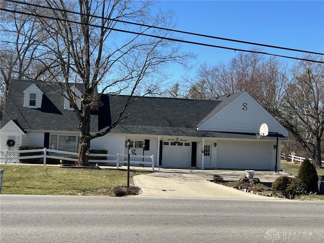 view of front of house with a fenced front yard, driveway, a front yard, and a garage