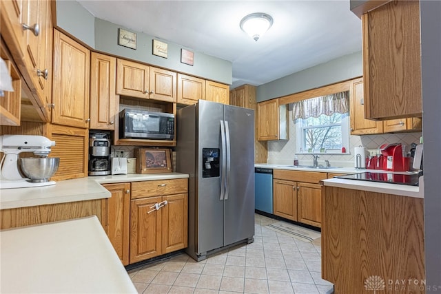 kitchen with sink, stainless steel appliances, and tasteful backsplash