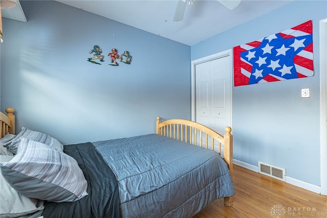 bedroom with hardwood / wood-style floors, ceiling fan, and a closet