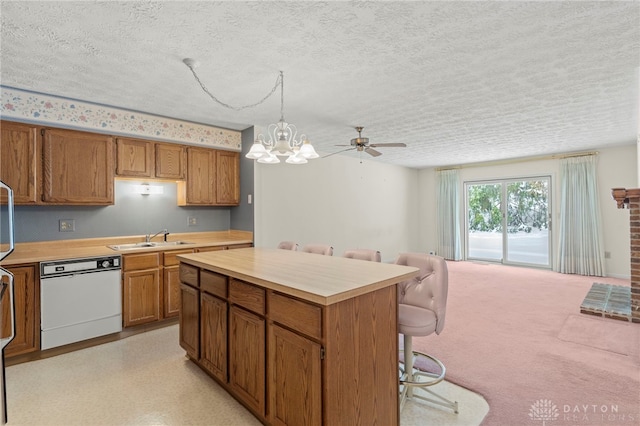 kitchen with sink, white dishwasher, a textured ceiling, decorative light fixtures, and ceiling fan with notable chandelier