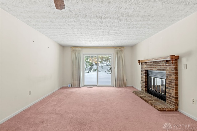 unfurnished living room with carpet flooring, a fireplace, and a textured ceiling