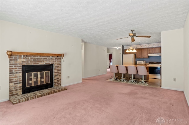 living room featuring a fireplace, a textured ceiling, light colored carpet, and ceiling fan