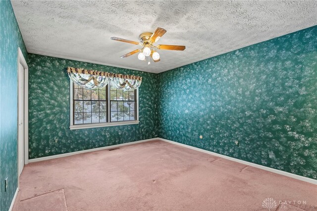 spare room with carpet and ceiling fan