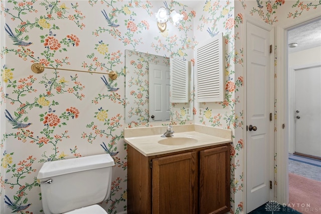 bathroom with vanity, a textured ceiling, and toilet