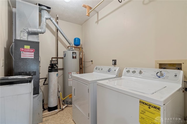 washroom featuring a textured ceiling, gas water heater, and washer and clothes dryer