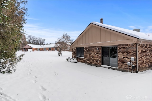 view of snow covered rear of property