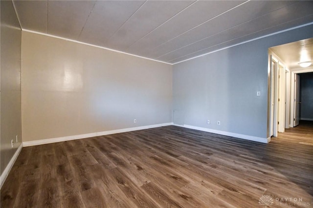 empty room featuring dark hardwood / wood-style floors and ornamental molding