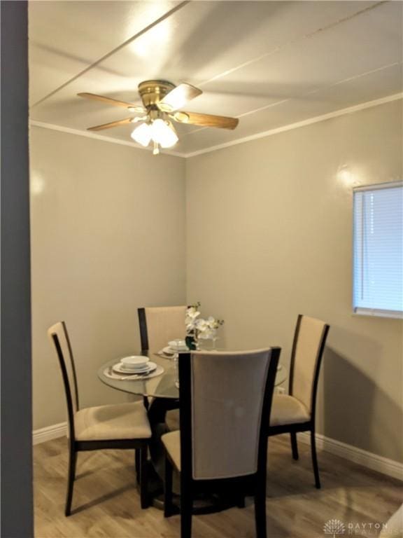 dining space with ceiling fan, wood-type flooring, and ornamental molding