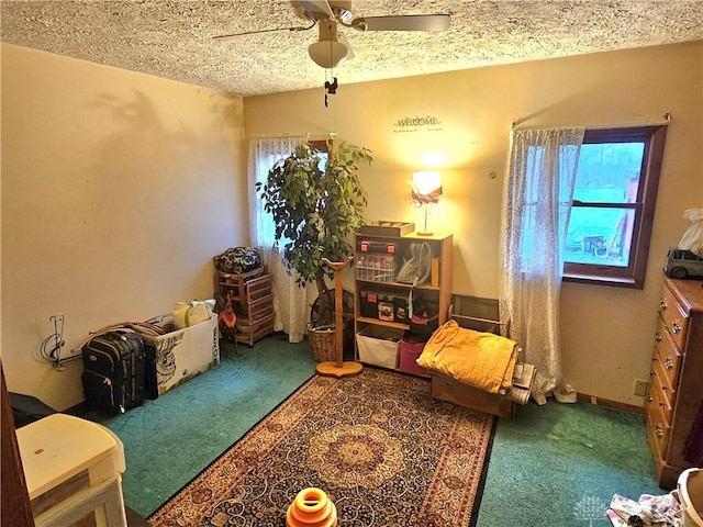 living area featuring carpet, a textured ceiling, and ceiling fan