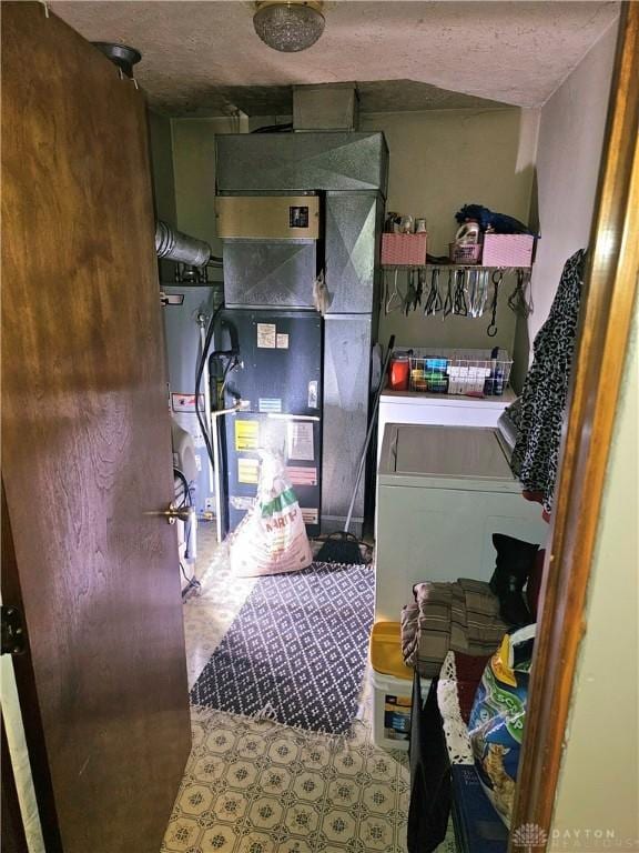 laundry area featuring gas water heater, separate washer and dryer, a textured ceiling, and heating unit