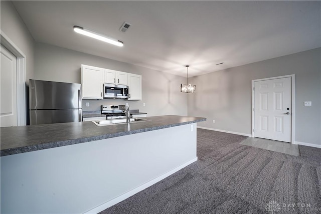 kitchen featuring a notable chandelier, white cabinets, dark colored carpet, decorative light fixtures, and stainless steel appliances