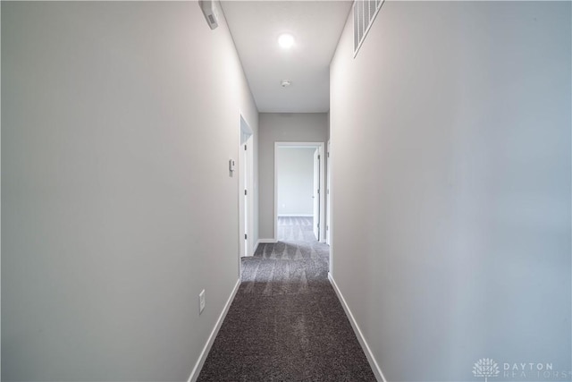 corridor featuring dark colored carpet