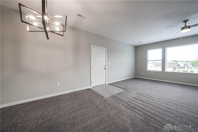 unfurnished living room featuring dark carpet and ceiling fan with notable chandelier