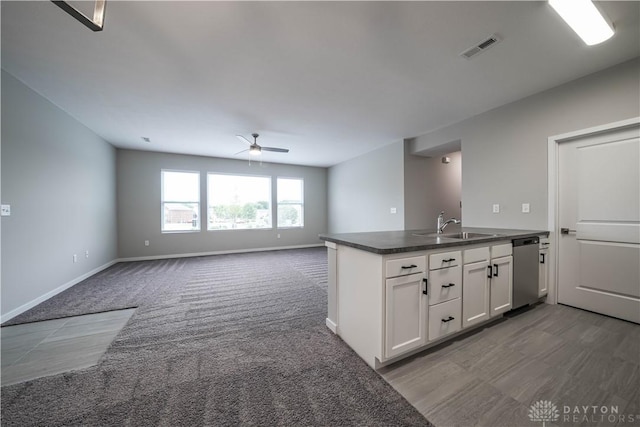 kitchen with carpet flooring, white cabinetry, dishwasher, sink, and kitchen peninsula