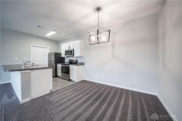 kitchen featuring white cabinets, sink, decorative light fixtures, kitchen peninsula, and stainless steel appliances