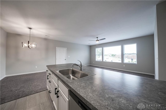 kitchen featuring ceiling fan with notable chandelier, sink, pendant lighting, white cabinets, and dark hardwood / wood-style floors