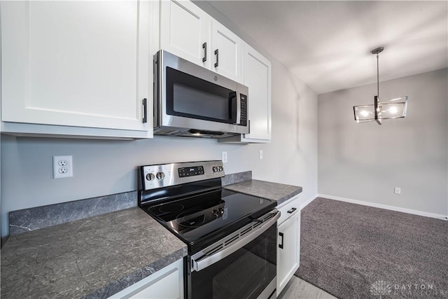 kitchen with white cabinets, carpet floors, stainless steel appliances, and hanging light fixtures