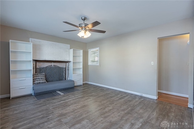 unfurnished living room featuring ceiling fan and dark hardwood / wood-style flooring