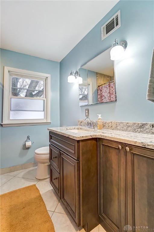 bathroom featuring toilet, vanity, tile patterned floors, and a shower with shower curtain