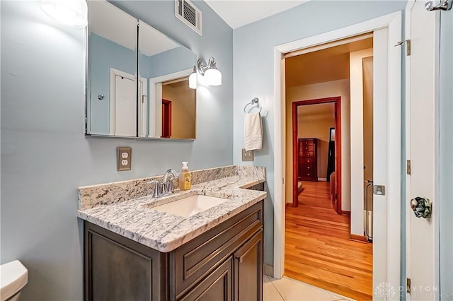 bathroom featuring tile patterned flooring, vanity, and toilet