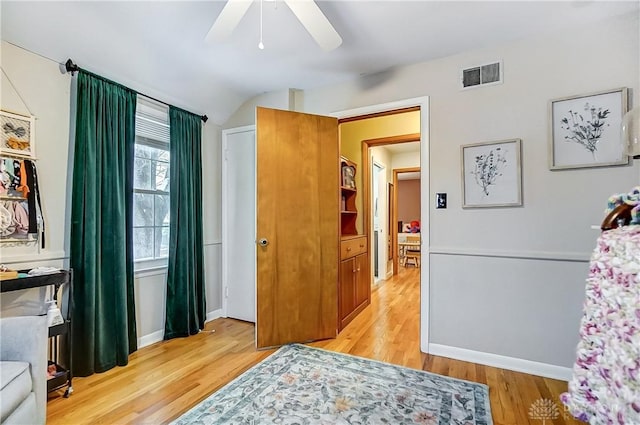 bedroom featuring light hardwood / wood-style floors, vaulted ceiling, and ceiling fan