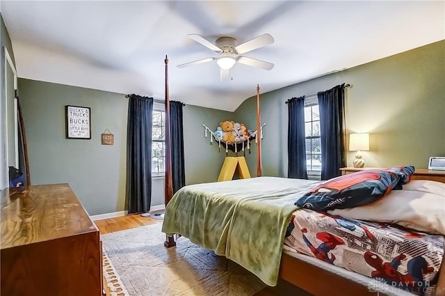 bedroom featuring hardwood / wood-style floors, vaulted ceiling, and ceiling fan