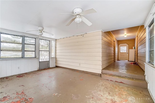 unfurnished sunroom featuring ceiling fan