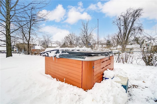 yard layered in snow with a hot tub