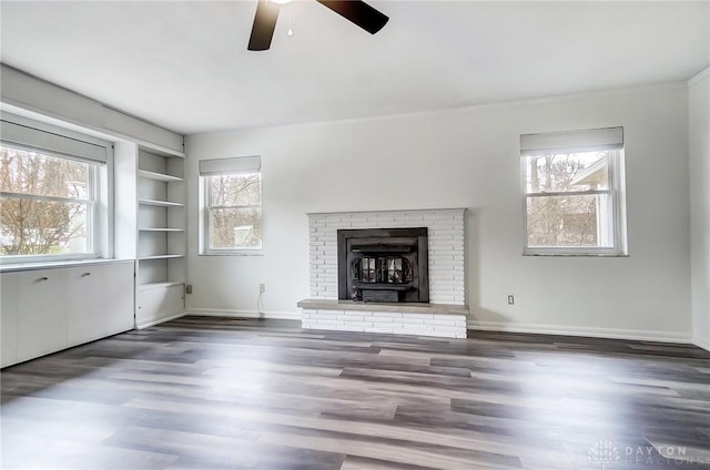 unfurnished living room with dark hardwood / wood-style floors, built in features, and a wealth of natural light