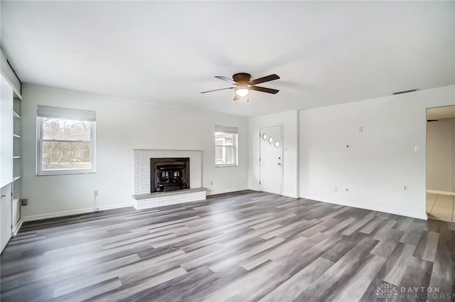 unfurnished living room with a fireplace, wood-type flooring, built in features, and ceiling fan